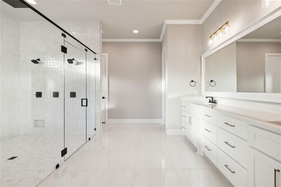 Bathroom with vanity, an enclosed shower, and crown molding