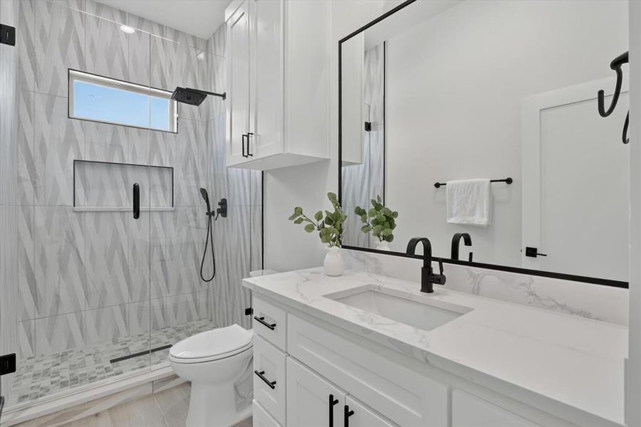Bathroom featuring a white vanity with slab countertop, undermount sink, and matte black faucet