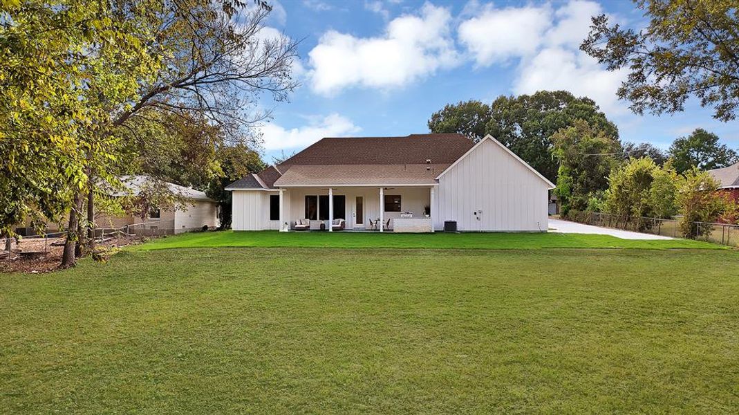 Back of house with a patio area, a shingled roof, and board and batten siding Back of house with a patio area, a shingled roof, and board and batten siding