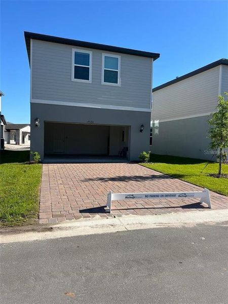 Front exterior of a new home in The Meadow at Crossprairie Bungalows, St. Cloud, FL, highlighting curb appeal (Image 2).