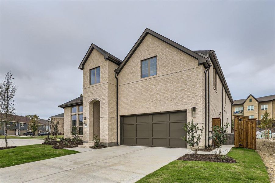 View of front facade with a garage and a front lawn