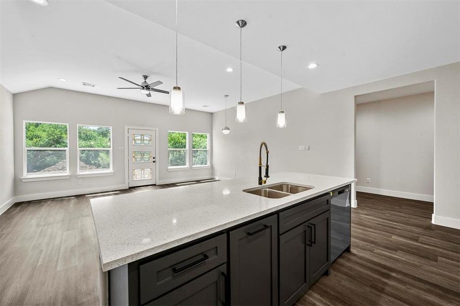 Kitchen with ceiling fan, dark hardwood / wood-style flooring, sink, dishwasher, and a kitchen island with sink