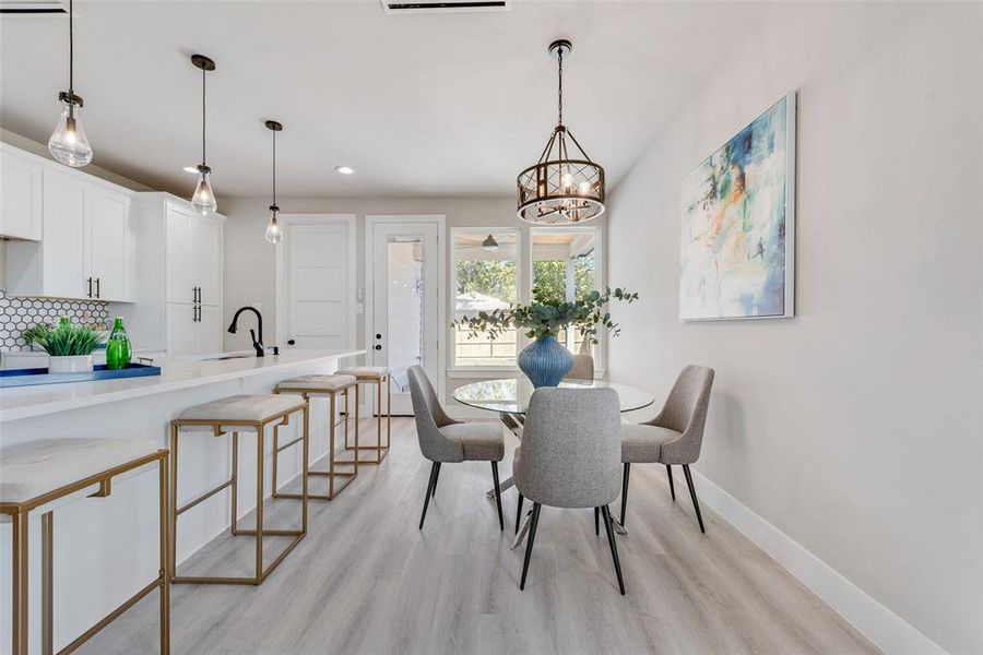 Dining room featuring an inviting chandelier, light hardwood / wood-style flooring, and sink