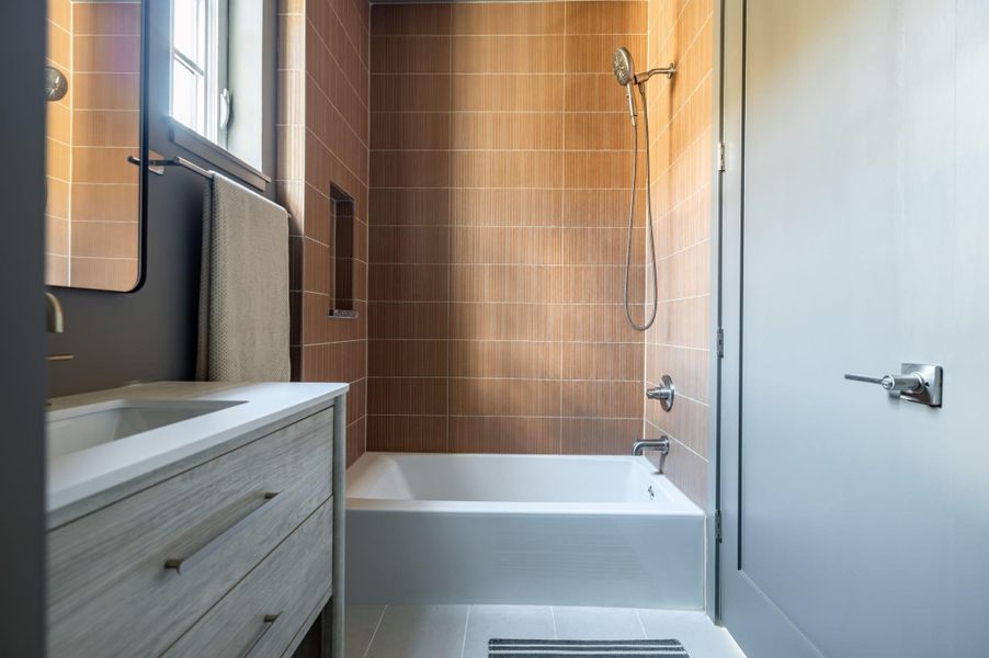 Textured tile surrounds the soaking tub in this contemporary bathroom setup. Textured tile surrounds the soaking tub in this contemporary bathroom setup.