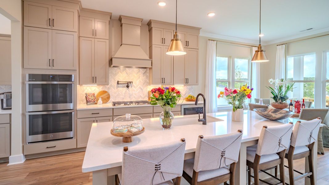 Kitchen with tile backsplash, quartz countertops, and pendant lighting Kitchen with tile backsplash, quartz countertops, and pendant lighting