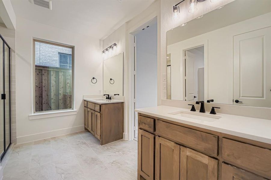 Bathroom featuring two vanities and a stall shower Bathroom featuring two vanities and a stall shower