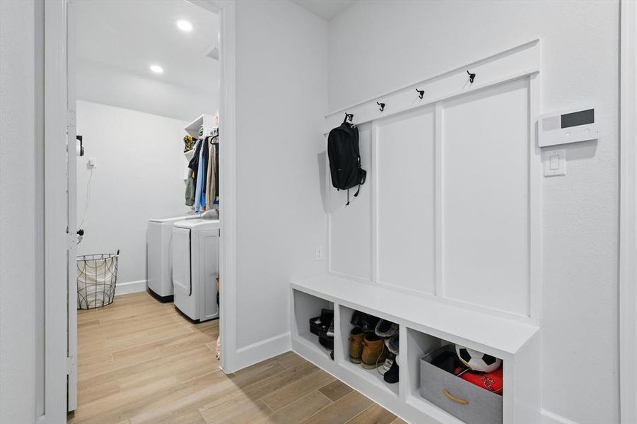 Mudroom with recessed lighting, baseboards, separate washer and dryer, and wood finished floors