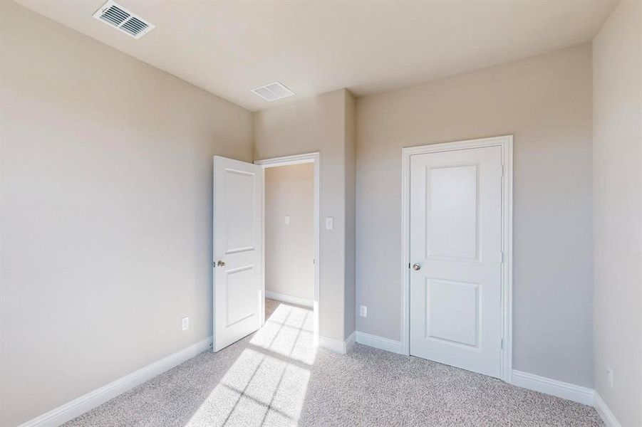 Unfurnished bedroom featuring light colored carpet