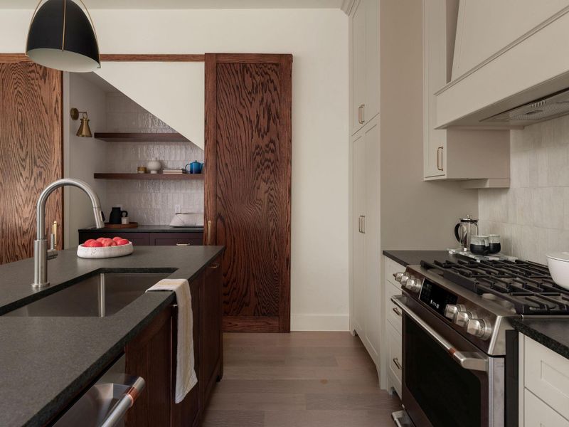 A well-appointed culinary space featuring a spacious island and modern stainless steel appliances.
