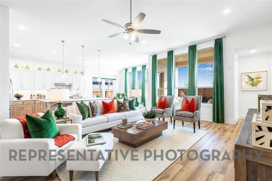 Living room featuring light wood-style flooring, healthy amount of natural light, a ceiling fan, and recessed lighting Living room featuring light wood-style flooring, healthy amount of natural light, a ceiling fan, and recessed lighting