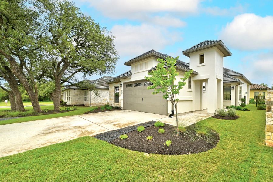 Contemporary stucco exterior with a prominent tower feature, dark tile roofing, and a two-car garage with a modern door