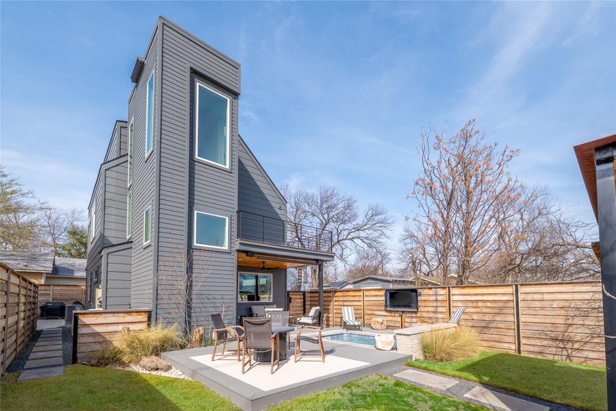 Rear view of property featuring a fenced backyard, outdoor dining space, a deck, and a patio