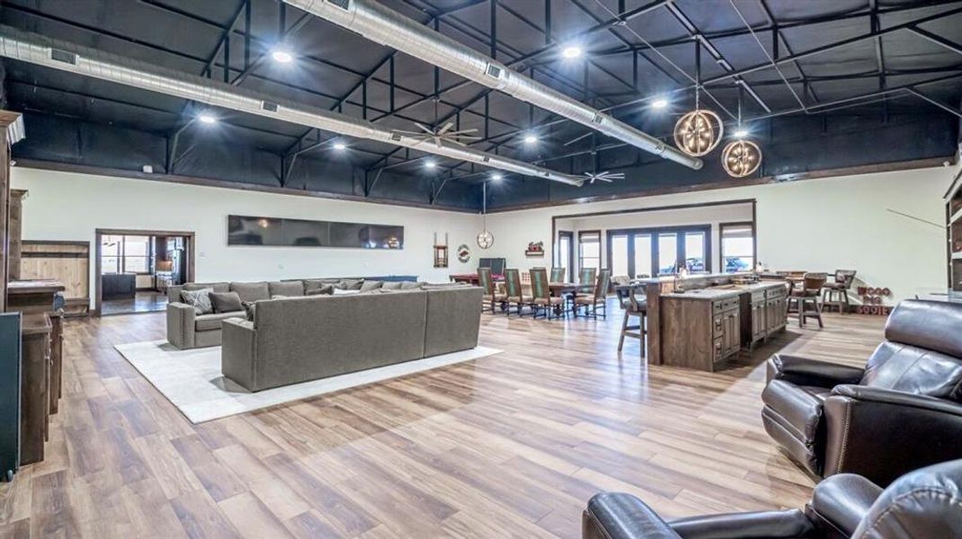 Living room featuring light wood-type flooring and a towering ceiling Living room featuring light wood-type flooring and a towering ceiling