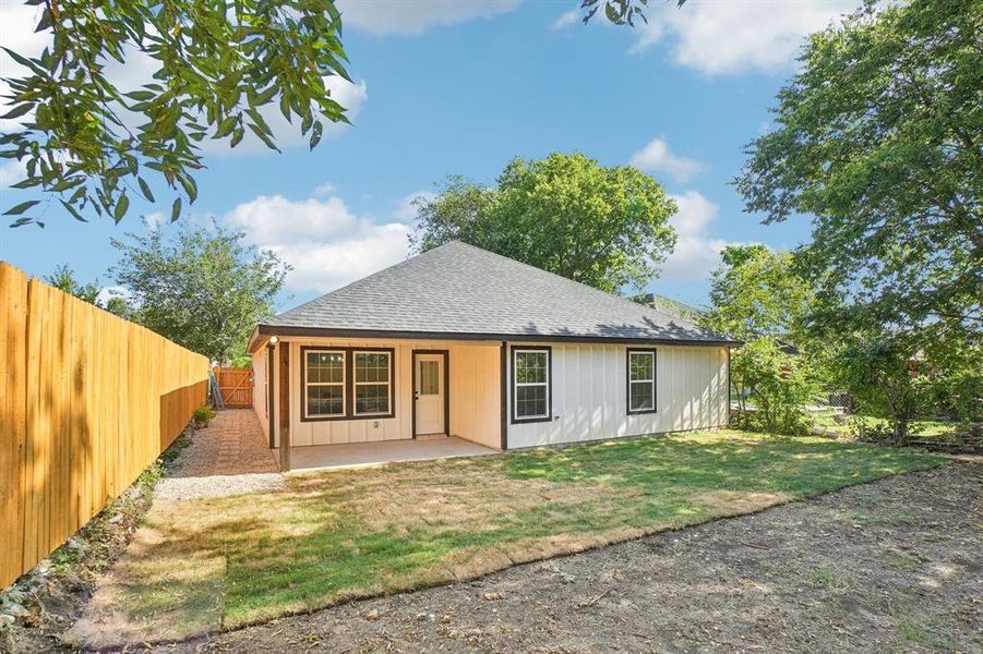 Back of property with a shingled roof, a patio, and a fenced backyard Back of property with a shingled roof, a patio, and a fenced backyard