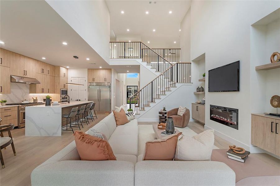 Living room featuring light hardwood / wood-style flooring and a high ceiling