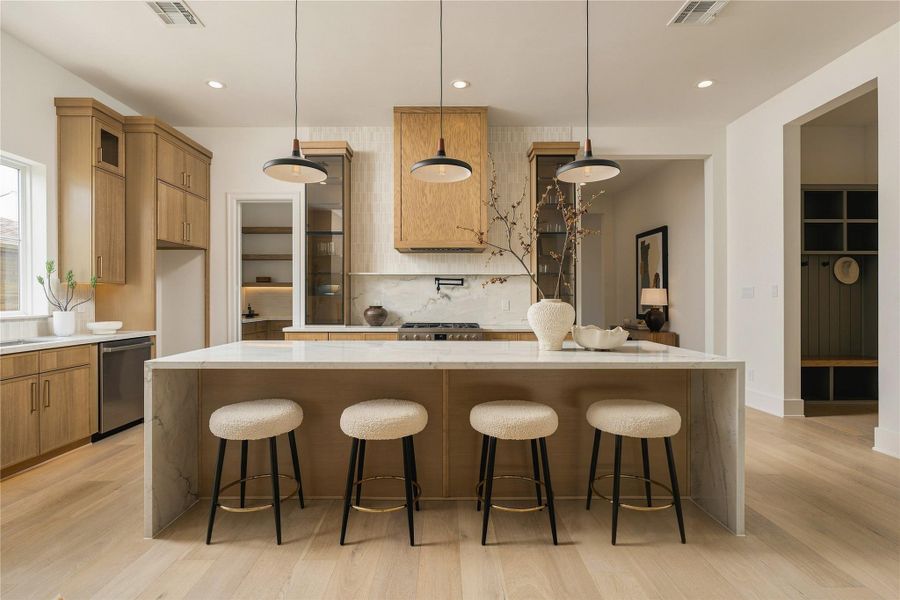 A front-facing view highlights the kitchen’s symmetry and tailored composition, with the oversized island anchoring the space and seating five comfortably for casual dining and conversation.
