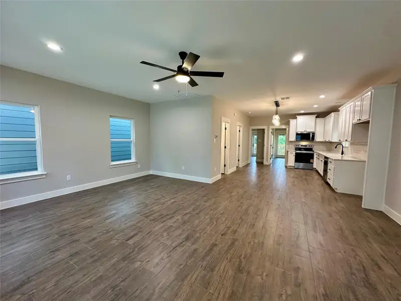 Unfurnished living room featuring recessed lighting, dark wood-style flooring, and a ceiling fan