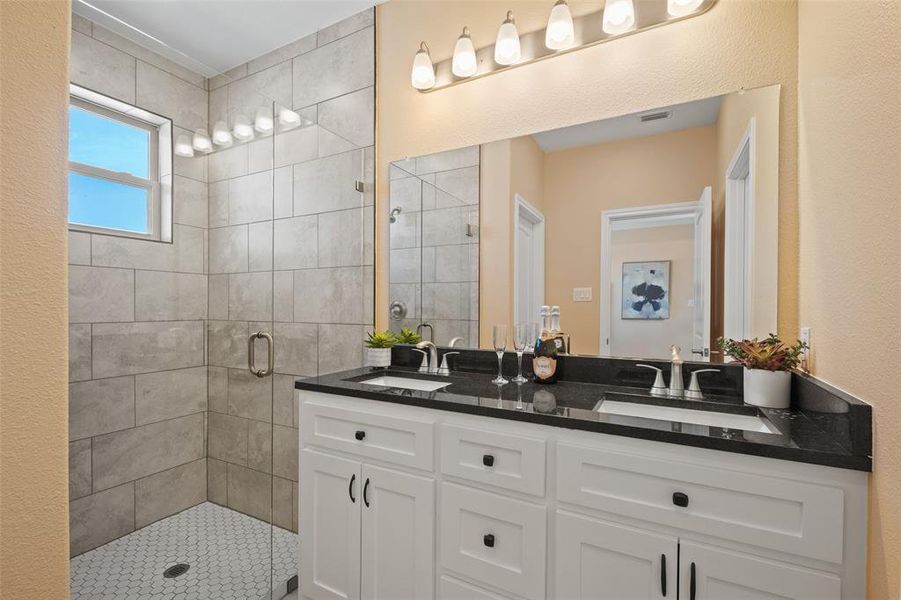 Dual vanity with black countertops and undermount sinks Dual vanity with black countertops and undermount sinks