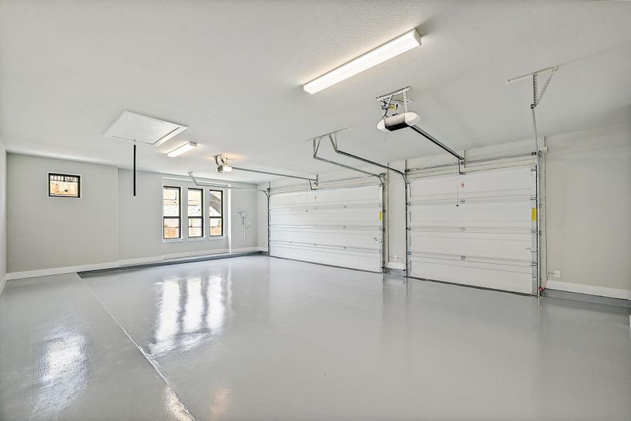 A spacious, naturally illuminated garage, with epoxy flooring, provides ample room for vehicles and storage. A spacious, naturally illuminated garage, with epoxy flooring, provides ample room for vehicles and storage.