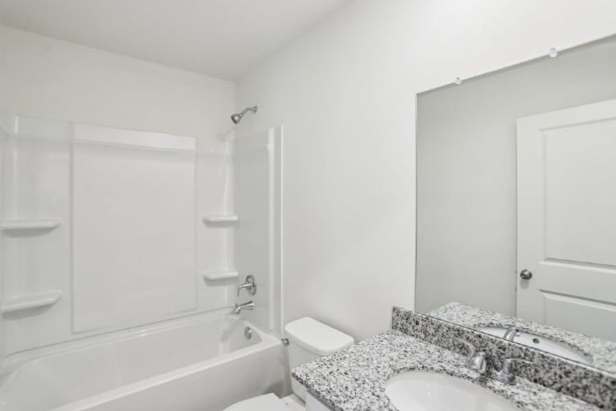 A bathroom with a tub sink and toilet.