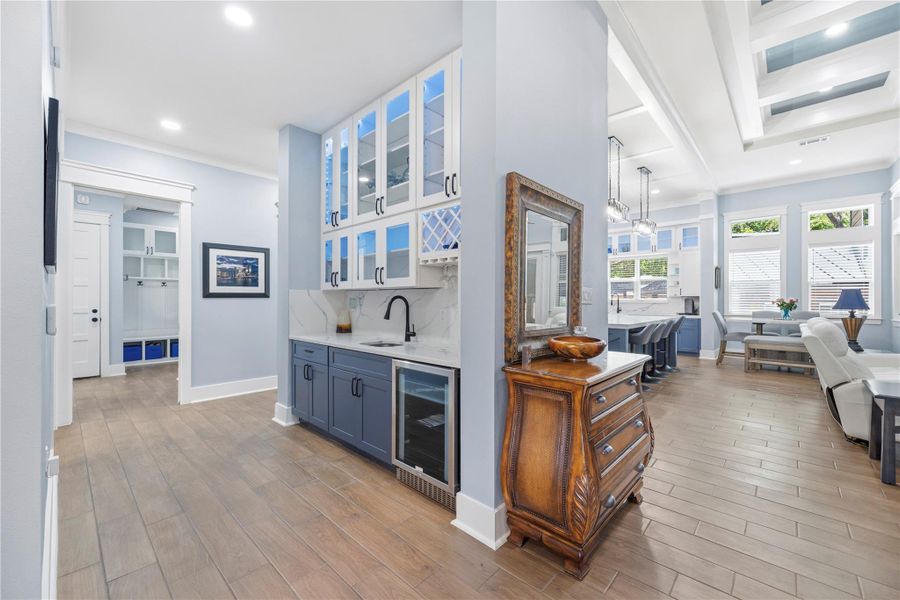 An elegant serving Butler's Bar adorned with illuminated glass cabinetry, curated wine storage, and sophisticated finishes.