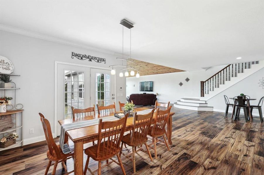 Dining room with an inviting chandelier, hardwood / wood-style floors, and french doors