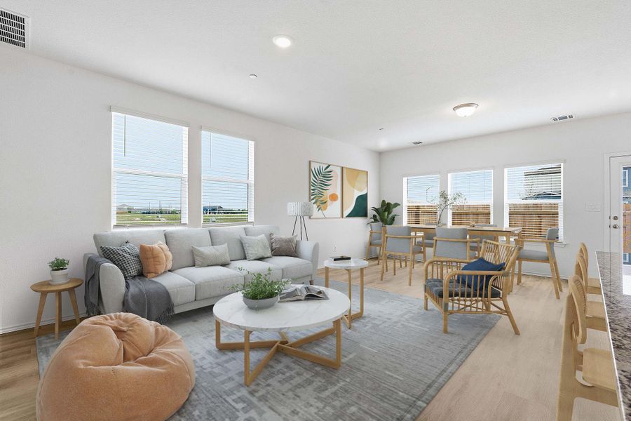 Open-concept living space featuring wood-finish flooring, recessed lighting, and multiple windows with blinds Open-concept living space featuring wood-finish flooring, recessed lighting, and multiple windows with blinds