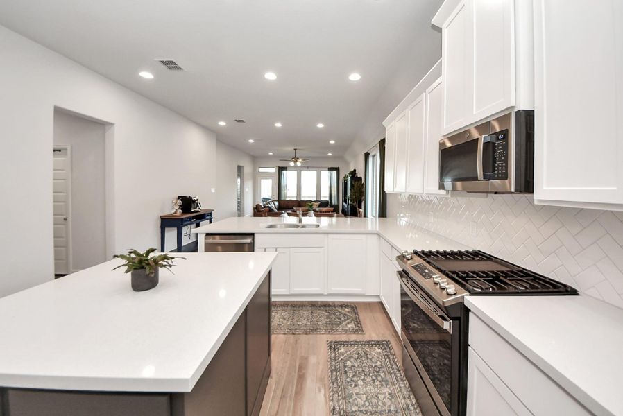 Flooded with natural light, the open kitchen layout emphasizes spaciousness and contemporary elegance. Light wood flooring, neutral walls, and stainless steel accents create a bright, versatile environment ideal for culinary creativity or entertaining in style.