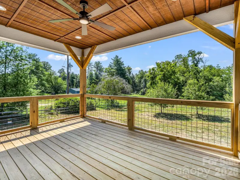 Large covered rear porch with fan overlooking flat useable almost acre lot Large covered rear porch with fan overlooking flat useable almost acre lot