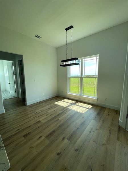 Unfurnished dining area with baseboards and wood finished floors Unfurnished dining area with baseboards and wood finished floors