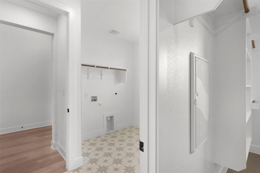 Laundry room with hookup for an electric dryer, hookup for a washing machine, and light wood finished floors