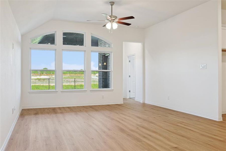 Unfurnished room with ceiling fan, light hardwood / wood-style flooring, and vaulted ceiling