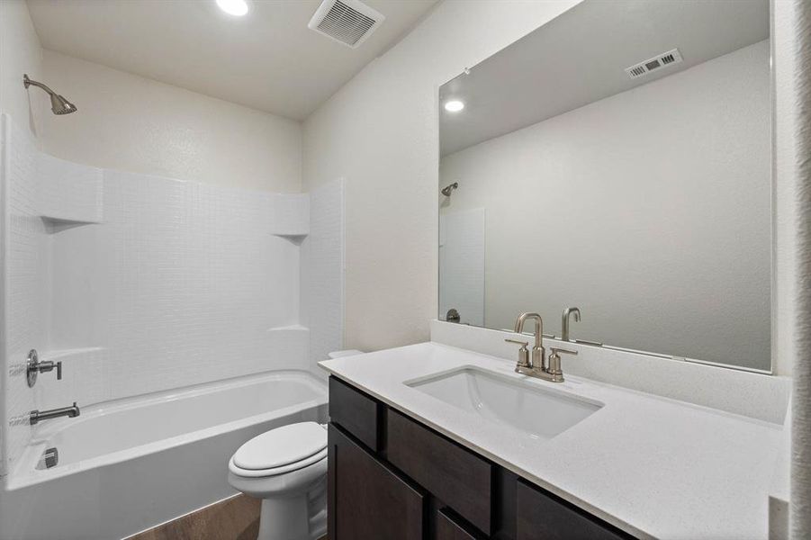 Full bathroom featuring wood-style flooring, vanity, toilet, and shower / tub combination