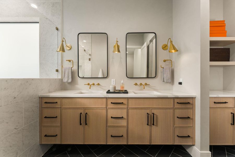 The primary ensuite bathroom has floating dual vanities and natural light.