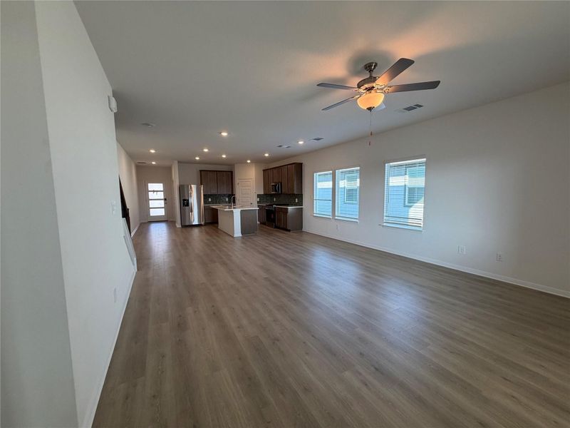 Unfurnished living room featuring dark wood-type flooring, recessed lighting, and ceiling fan