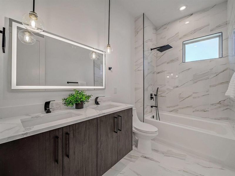 Full bath with double vanity, shower / washtub combination, and marble finish floors