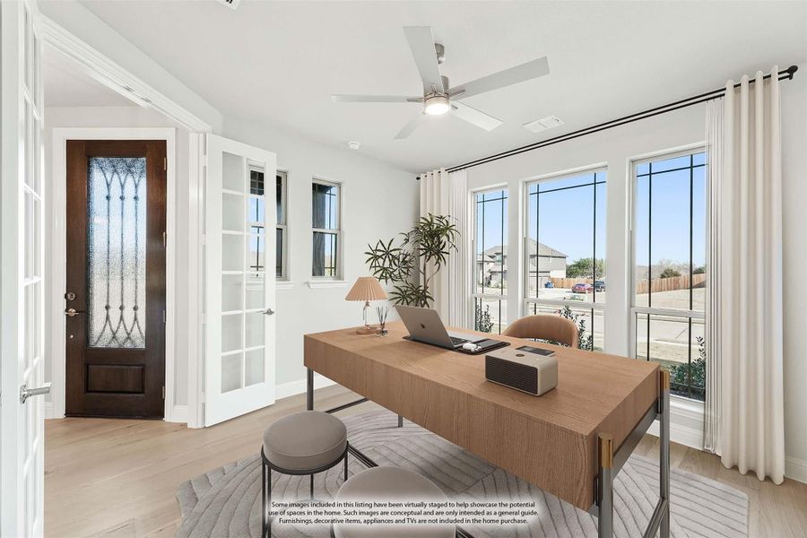 Home office with wood desk, ceiling fan, large windows, and decorative front door with glass inlay Home office with wood desk, ceiling fan, large windows, and decorative front door with glass inlay