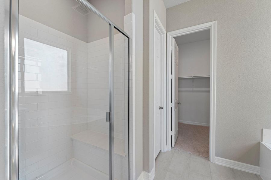 This additional view of your primary bathroom features tile flooring, fresh paint, walk-in shower, a separate garden tub, and a large walk-in closet. This additional view of your primary bathroom features tile flooring, fresh paint, walk-in shower, a separate garden tub, and a large walk-in closet.