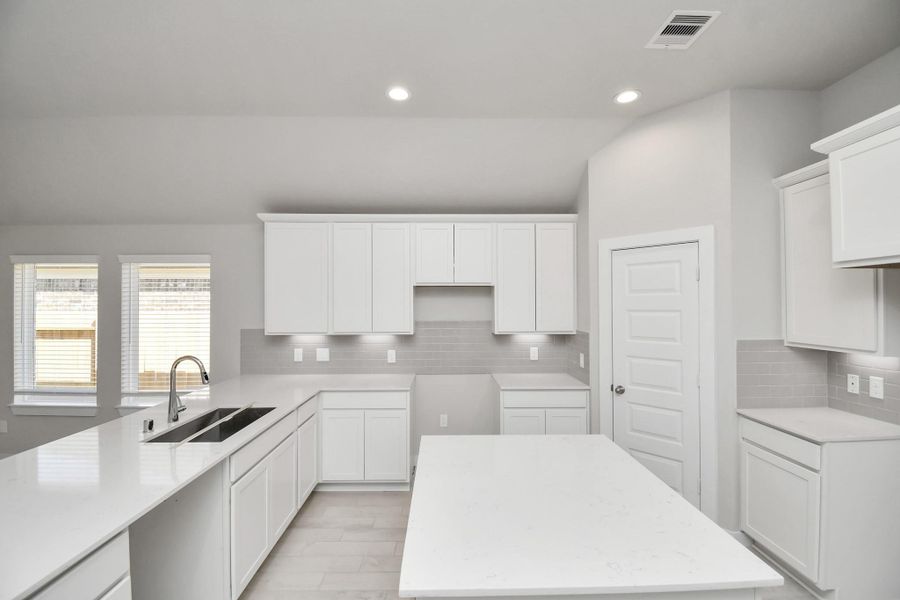 This kitchen is by far any chef’s dream! This spacious kitchen features high ceilings, white stained wood cabinets, granite countertop, SS appliances, modern tile backsplash, recessed lighting, extended counter space, granite kitchen island with, and a walk-in pantry all overlooking your huge family room. Sample photo of completed home with similar floor plan. Actual colors and selections may vary.