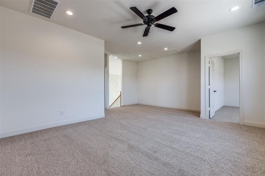 Empty room featuring ceiling fan and light colored carpet