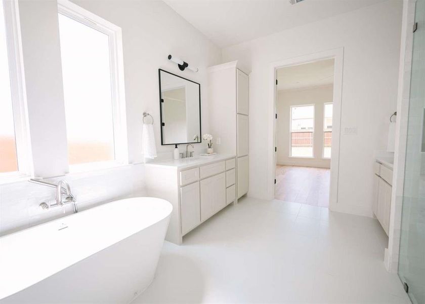 Bathroom with a bath, wood-type flooring, and oversized vanity