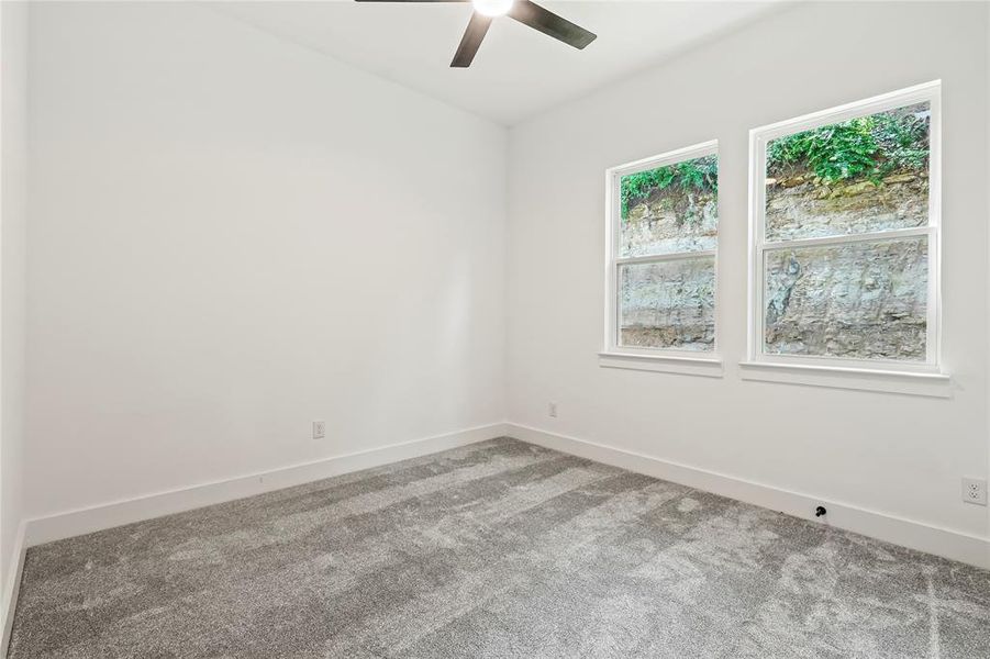 Unfurnished room featuring carpet and ceiling fan