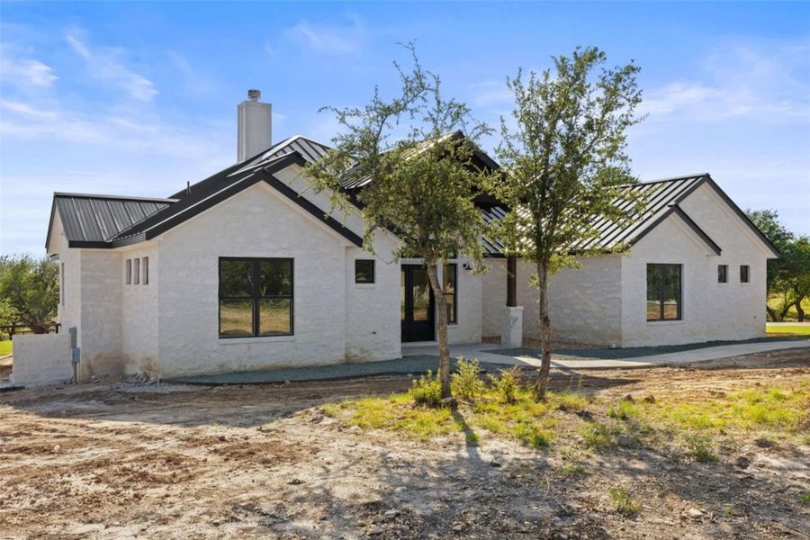 Modern farmhouse appeal defines this residence with a sleek metal roof and clean-lined architecture. Modern farmhouse appeal defines this residence with a sleek metal roof and clean-lined architecture.