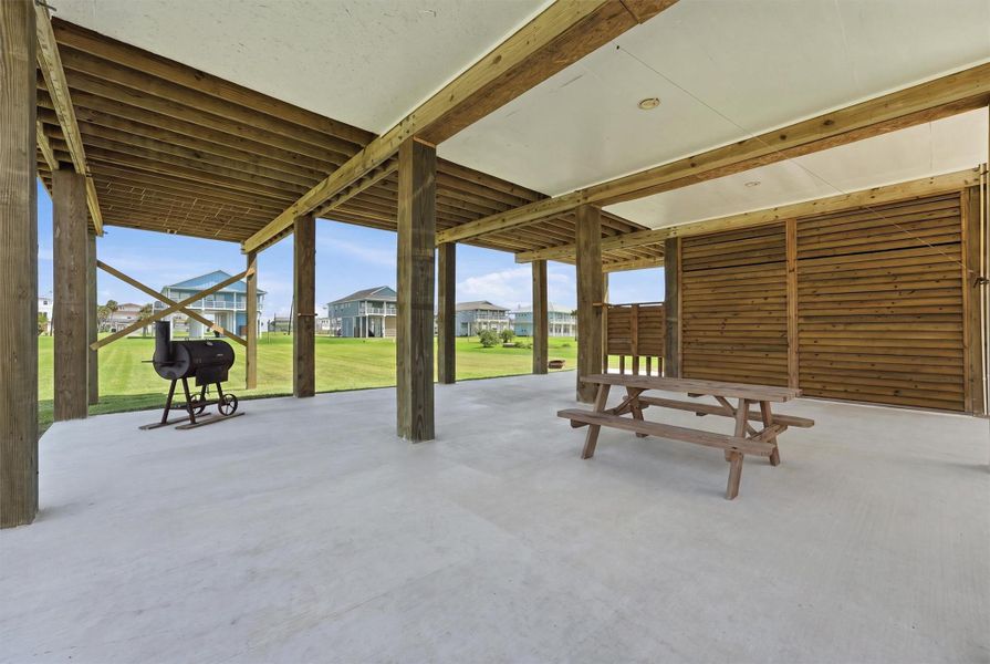 Spacious covered patio with a picnic table and grill, perfect for outdoor entertaining and relaxation, overlooking a lush green yard. Spacious covered patio with a picnic table and grill, perfect for outdoor entertaining and relaxation, overlooking a lush green yard.