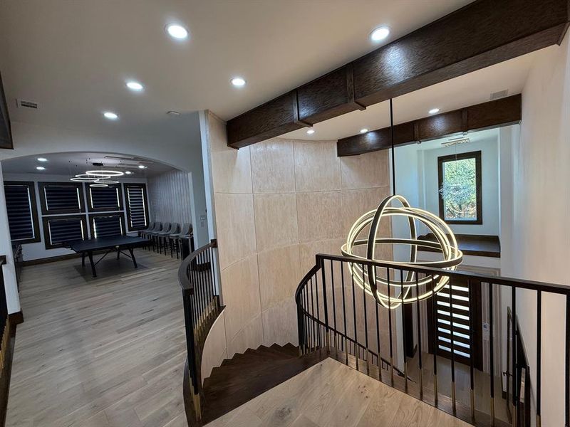 Stairs featuring a chandelier, wood finished floors, recessed lighting, beam ceiling, and arched walkways