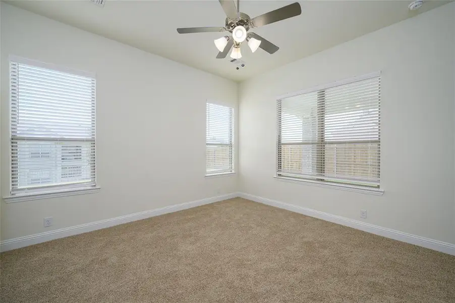 Carpeted empty room with ceiling fan