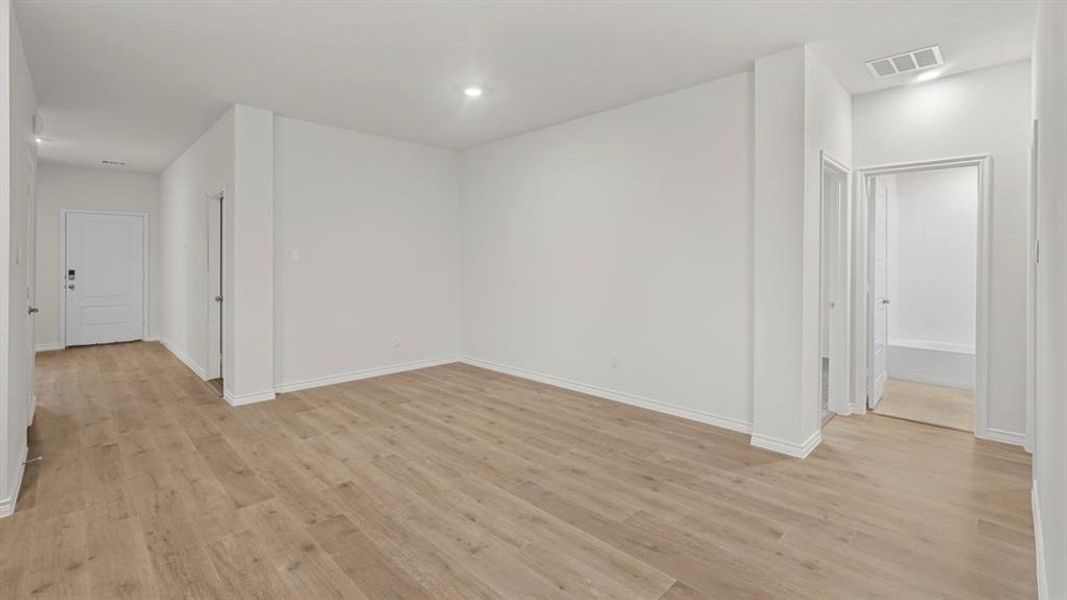 Open-concept room featuring wood-finish flooring, white baseboards, and recessed lighting