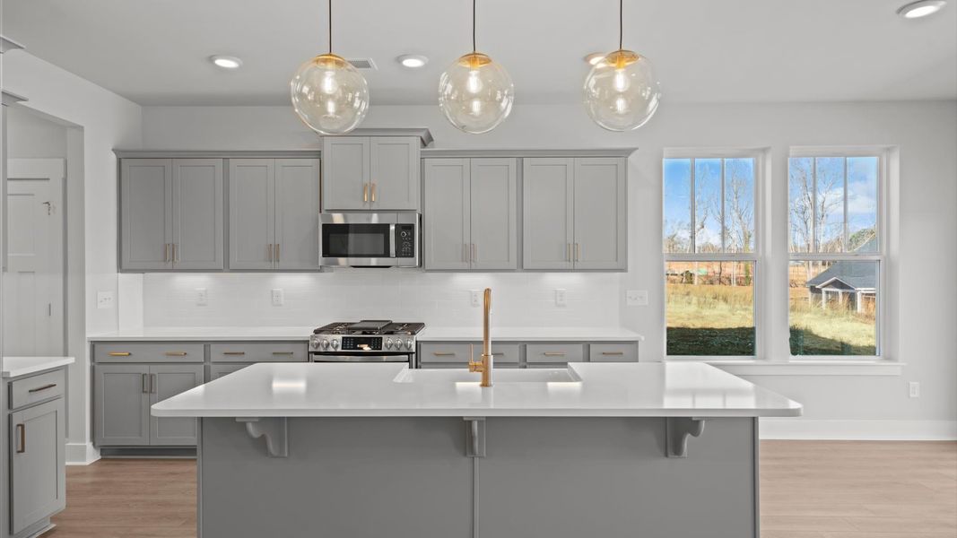Notable kitchen space with elegant pendant lighting and a large island perfect for entertaining