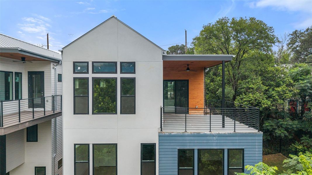 A modern facade with multiple large windows and a spacious outdoor deck awaits. A modern facade with multiple large windows and a spacious outdoor deck awaits.
