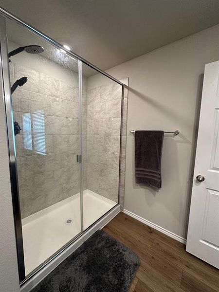 Bathroom with dark wood-type flooring and a stall shower
